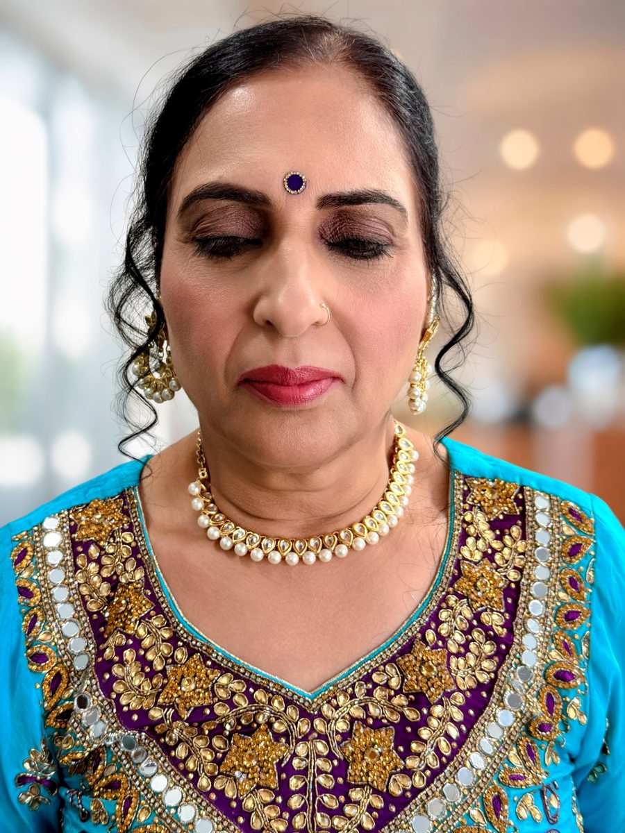 Close-up of shimmering bronze and plum eyeshadow with full lashes and a rose-berry lip for an engagement event