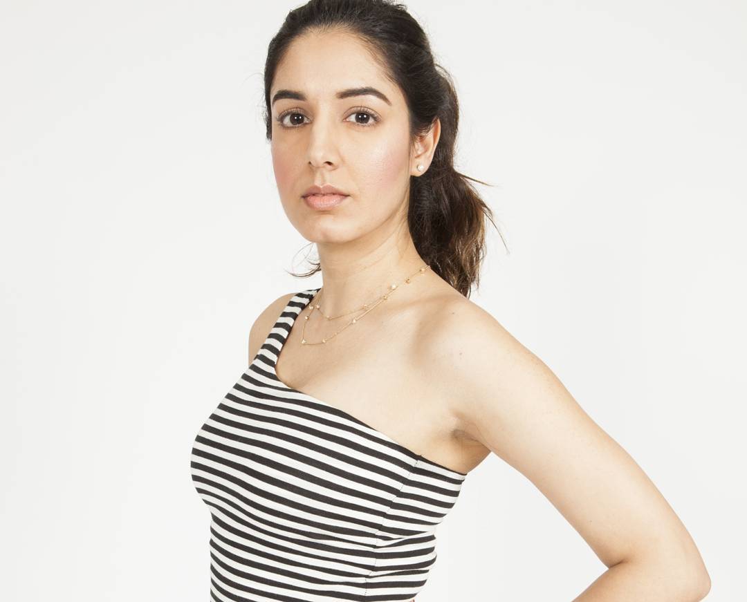 Editorial studio portrait with defined brows, glowing skin and a soft nude lip