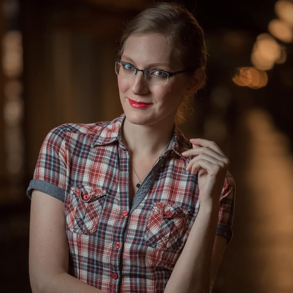 Professional headshot with clean camera-ready makeup, groomed brows and a bright red lip