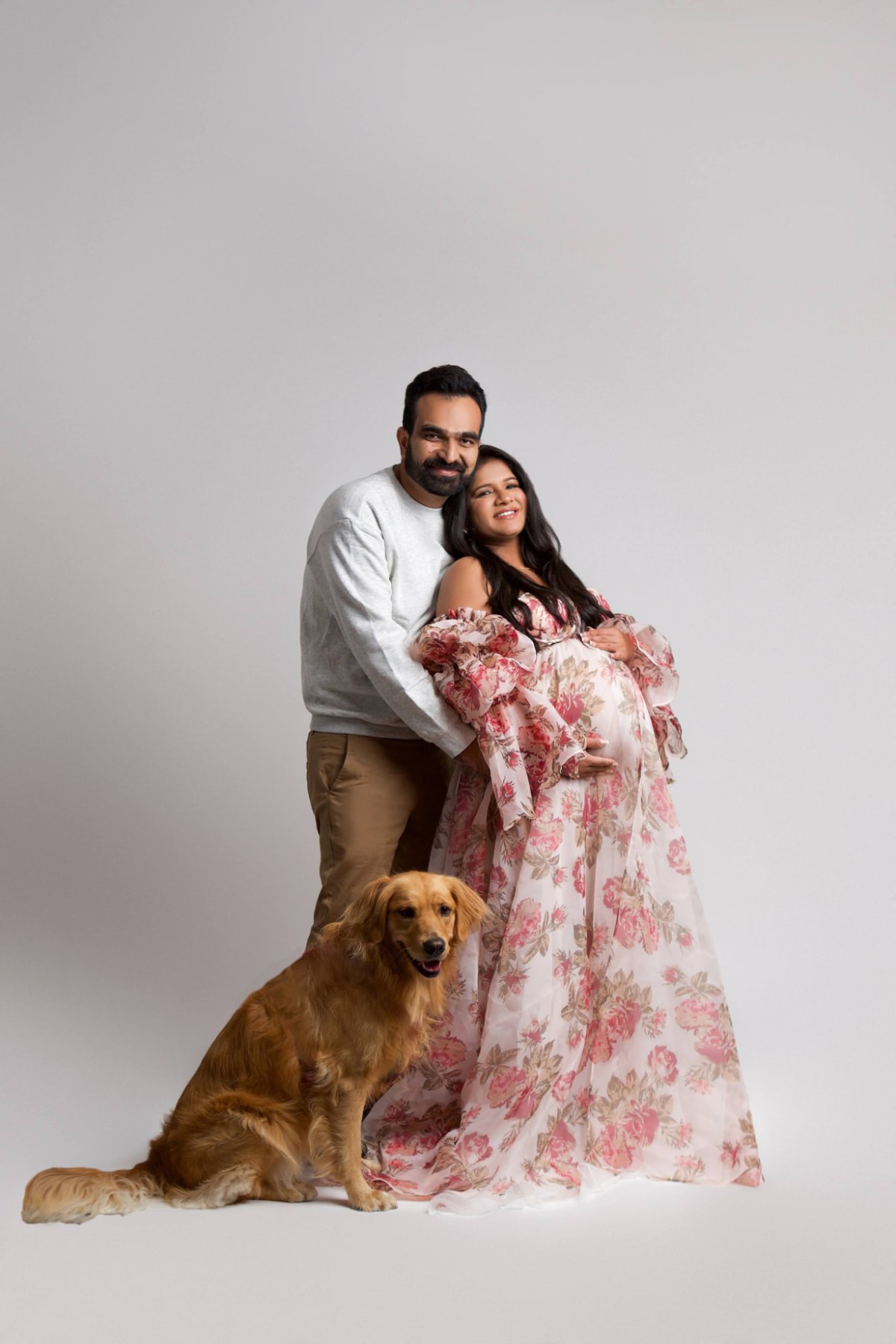 Couple maternity studio portrait with fresh camera-ready makeup and soft waves